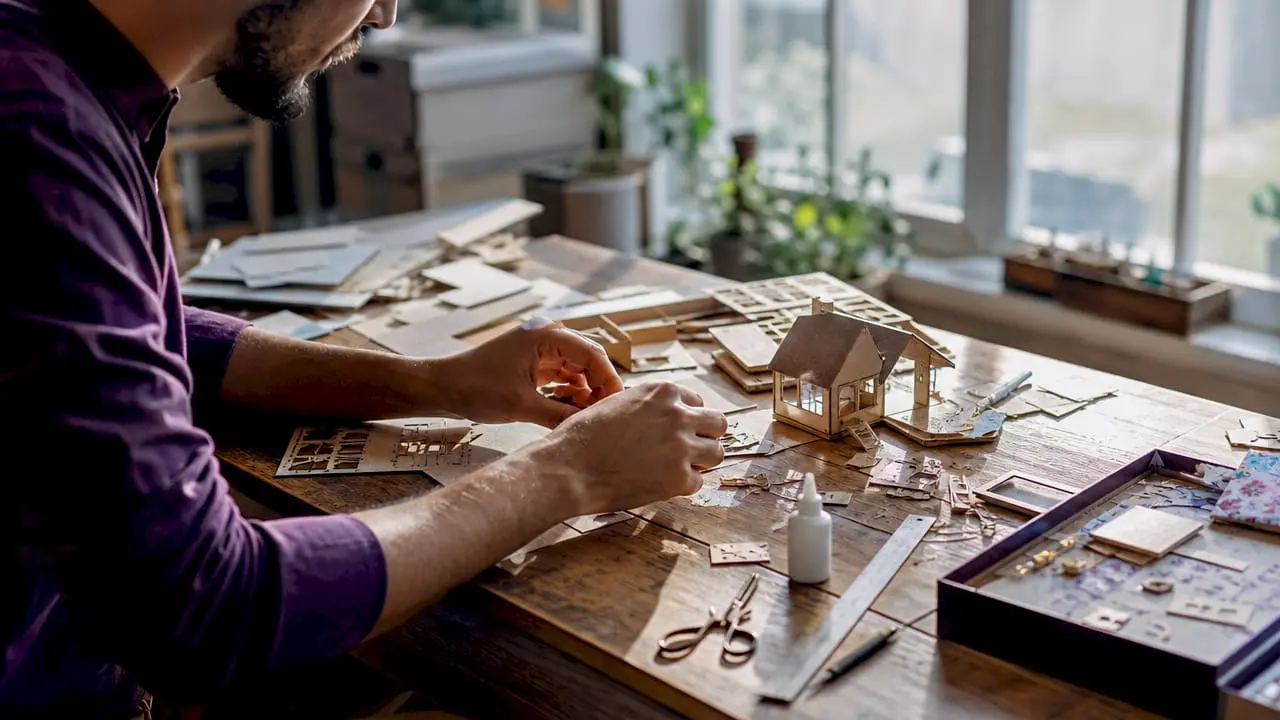 Hands organizing miniature kit components on desk